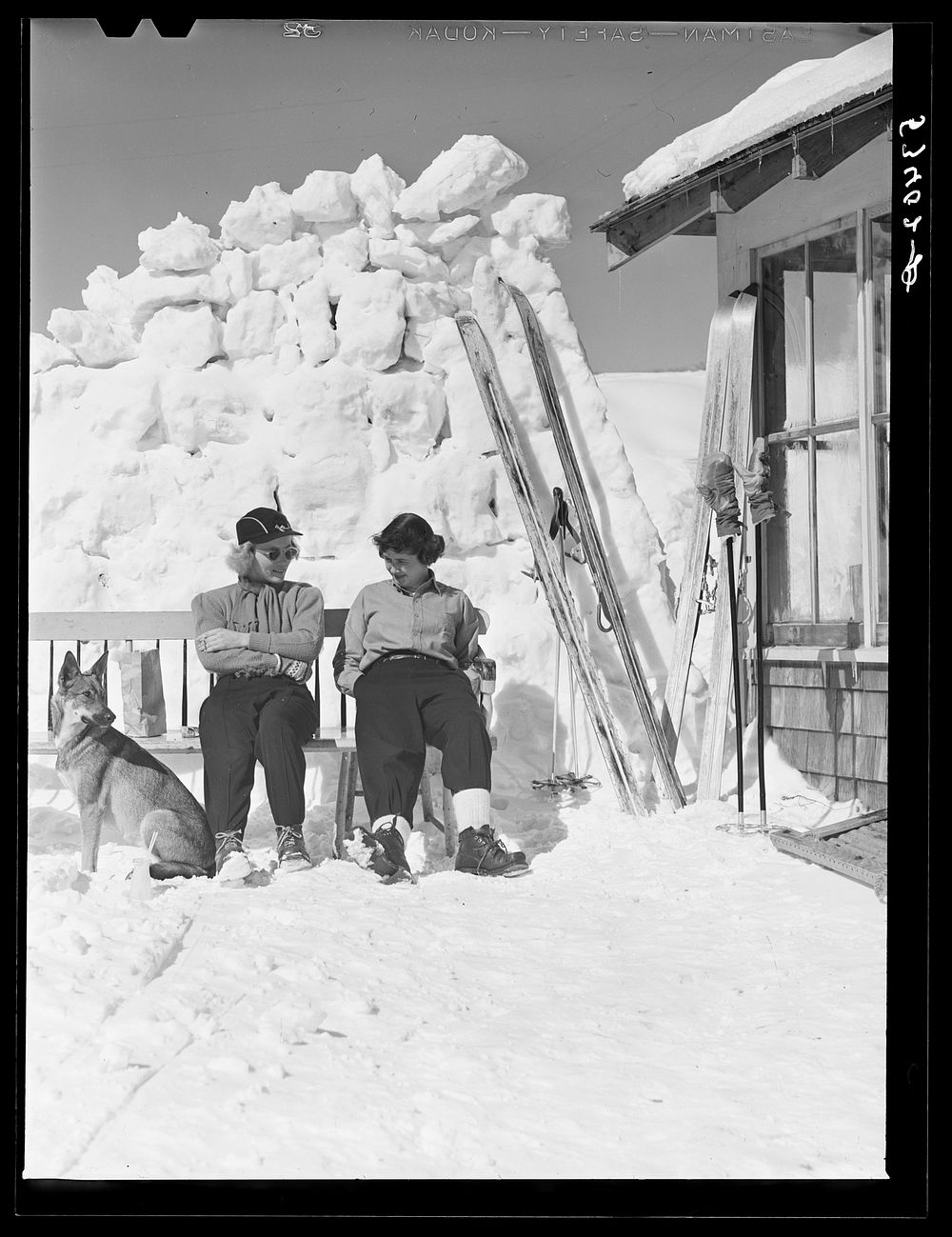 [Untitled photo, possibly related to: Skiers relaxing outside of lodge. North Conway, New Hampshire]. Sourced from the…