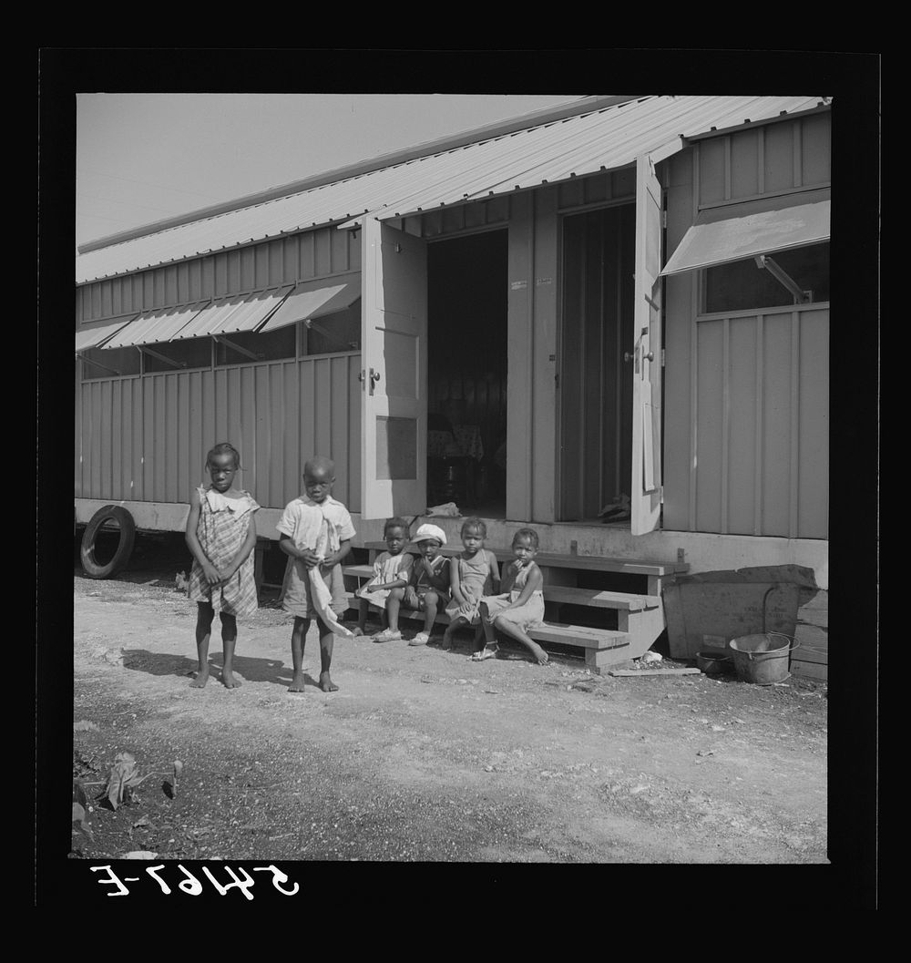 [Untitled photo, possibly related to: Children of camp members playing outside their shelters in Okeechobee migratory labor…