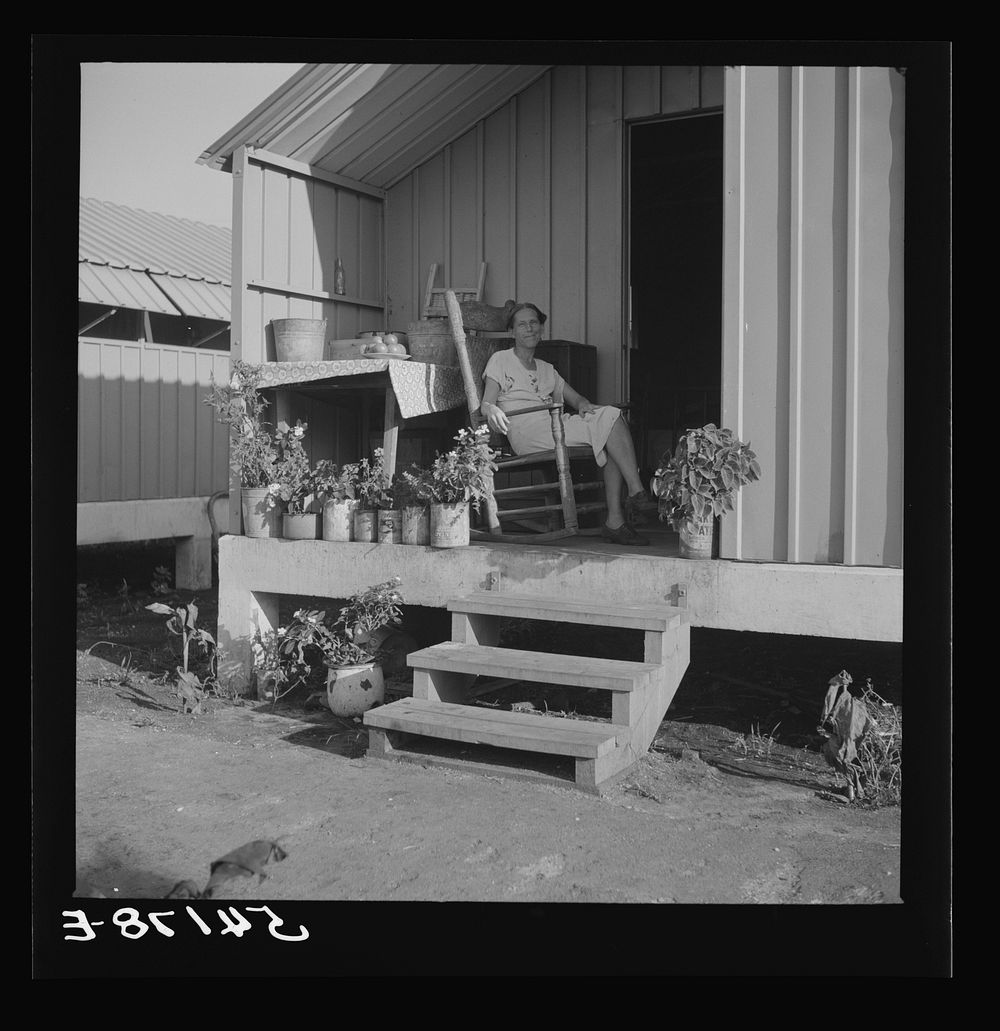 Camp member on porch of her shelter at Osceola migratory labor camp. Belle Glade, Florida. Sourced from the Library of…