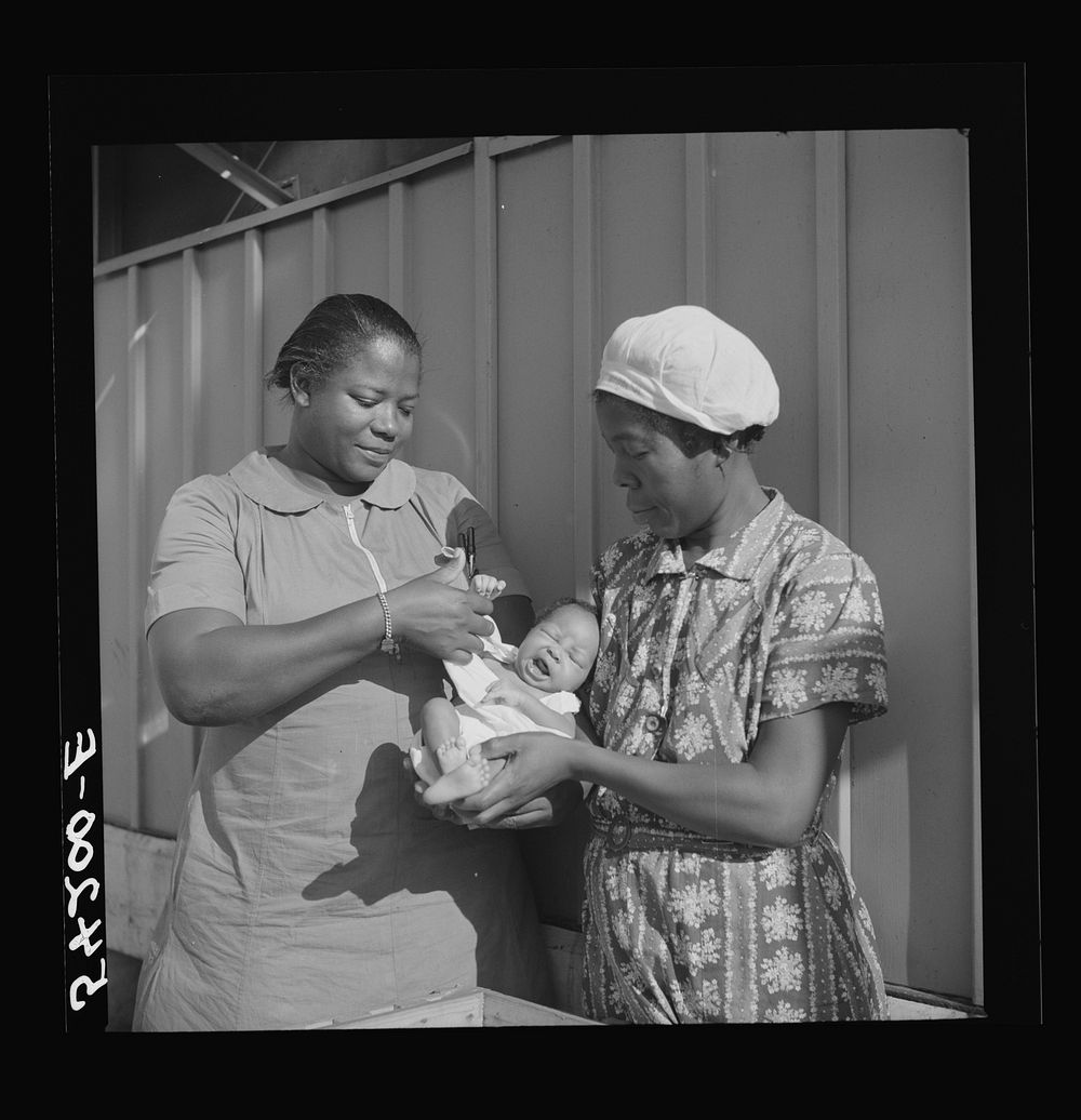 The nurse examines one of the camp's first babies. Mother and child are given both prenatal and postnatal care by nurse and…