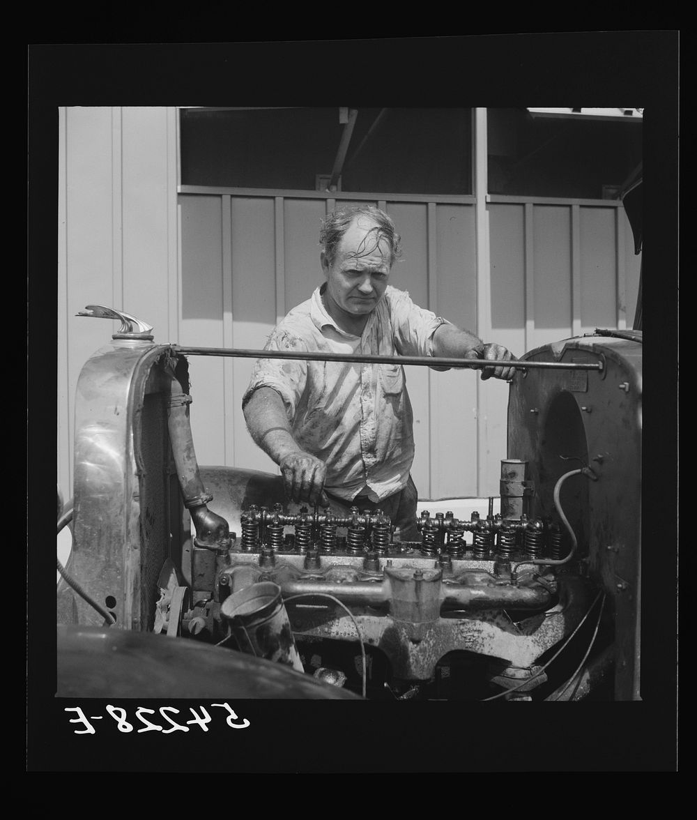 Camp member repairing his car outside his shelter. Osceola migratory labor camp. Belle Glade, Florida. Sourced from the…