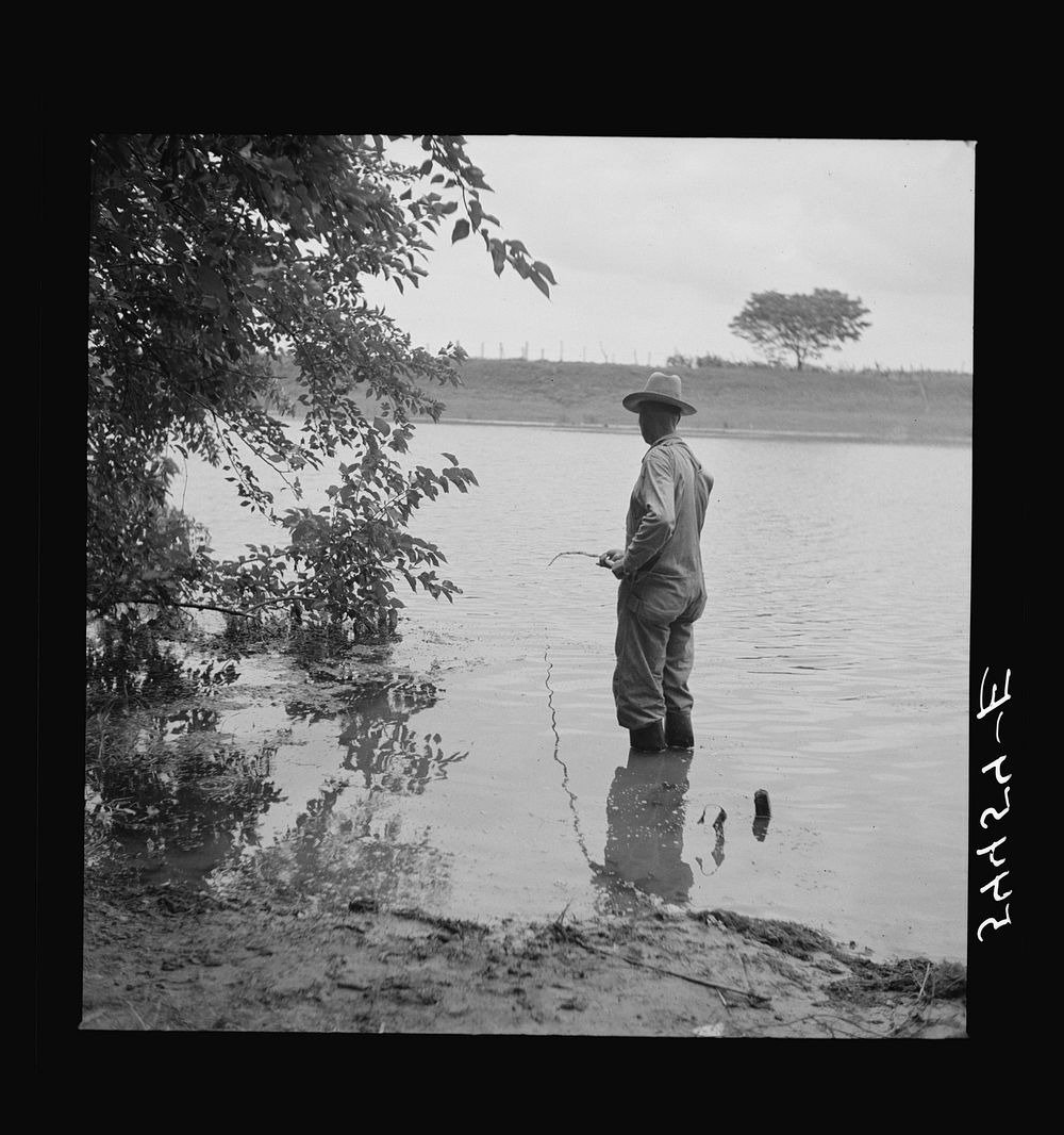 Farmer fishing in Cane River on Fourth of July. Near Natchitoches, Louisiana. Sourced from the Library of Congress.