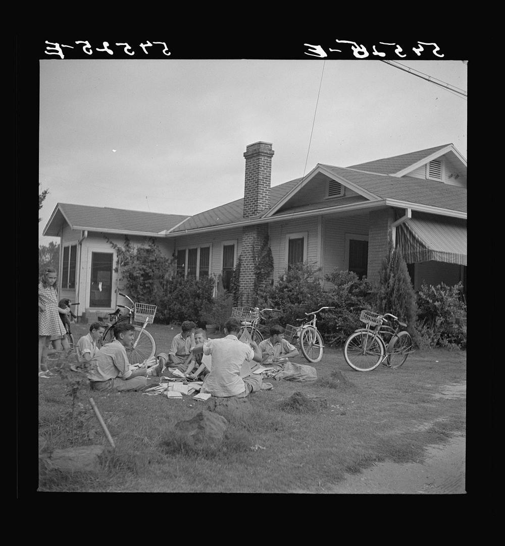 [Untitled photo, possibly related to: Boys in Natchitoches, Louisiana, folding papers before delivering them in the…