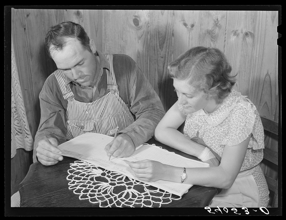 Mr. and Mrs. Verden Lee working on their farm and home family record book. Transylvania Project, Louisiana. Sourced from the…