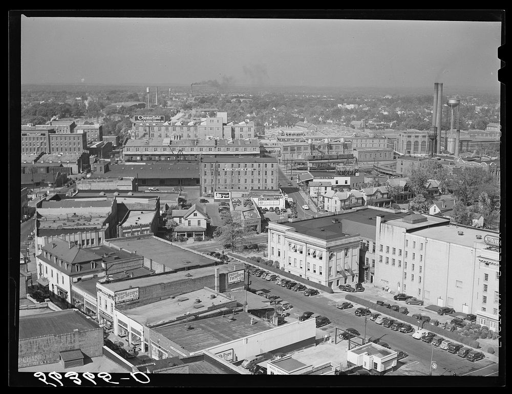 Center of city, with Chesterfield cigarette factory in background. Durham, North Carolina. Sourced from the Library of…