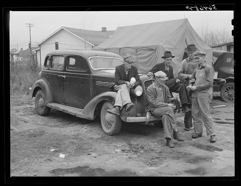 [Untitled photo, possibly related to: Men on car by tents. Construction workers in front of tents. Names: William Allen…