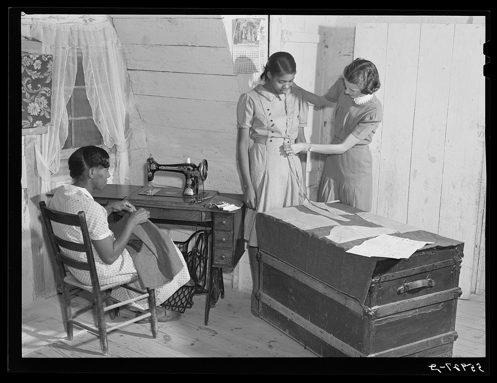FSA (Farm Security Administration) home supervisor Miss Horton helping one of borrower's families cut pattern and make their…