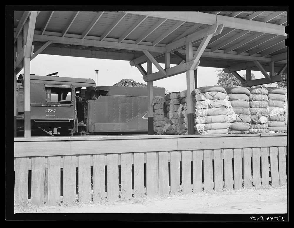 Railway station with bales of cotton on platform. Mebane, North Carolina. Sourced from the Library of Congress.