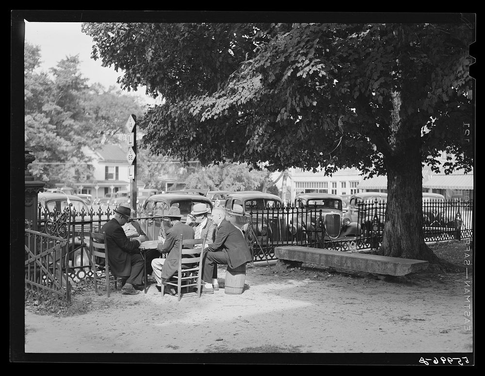 Men playing cards in yard in front of court house in Yanceyville, Caswell County, North Carolina. Sourced from the Library…