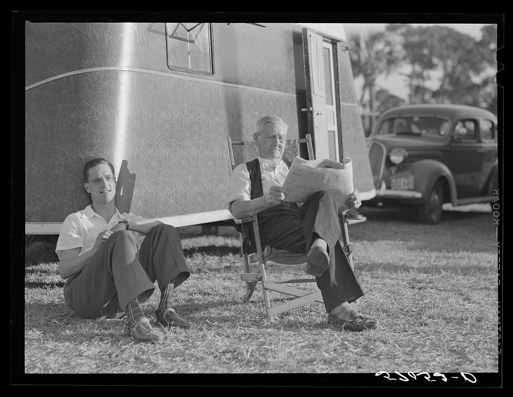 [Untitled photo, possibly related to: Reading the newspaper outside his trailer home. Sarasota trailer park, Sarasota…