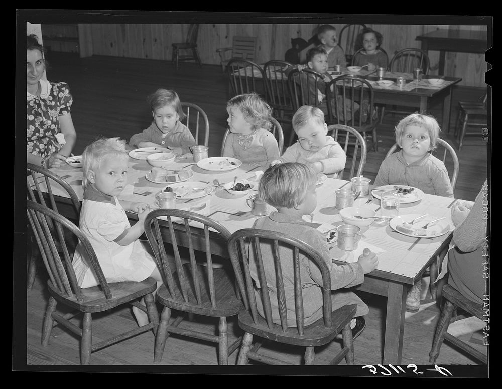 Children of migratory workers eating lunch in twenty-four hour nursery at Osceola migratory labor camp built by FSA (Farm…