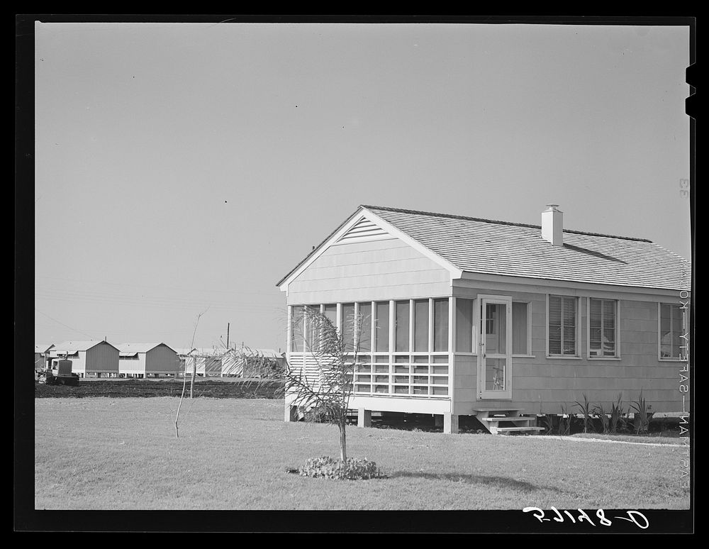 Labor home with metal shelters in background for agricultural workers. Osceola migratory labor camp, Belle Glade, Florida.…
