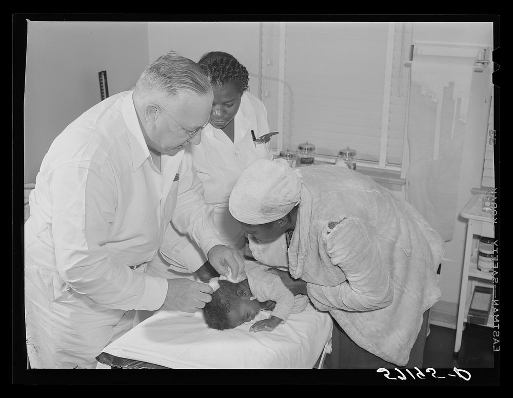 Dr. William Buck treating migratory worker's child in clinic. Okeechobee migratory labor camp, Belle Glade, Florida. Sourced…