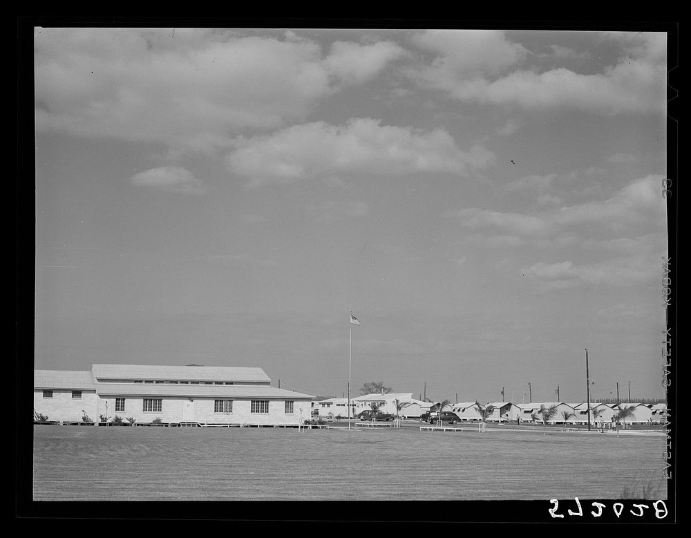 General view, community building, utilities and metal shelters for agricultural workers at Osceola migratory labor camp.…