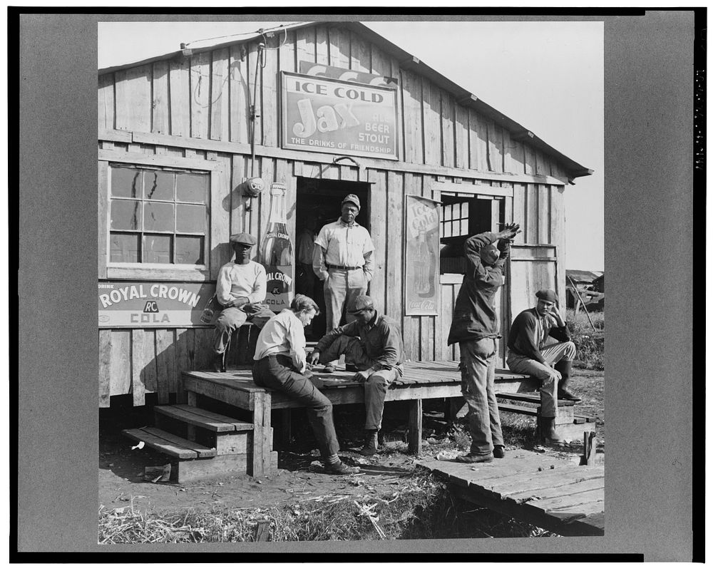 Migratory laborers playing checkers in front of jook joint during slack season for vegetable pickers. Belle Glade, Florida.…