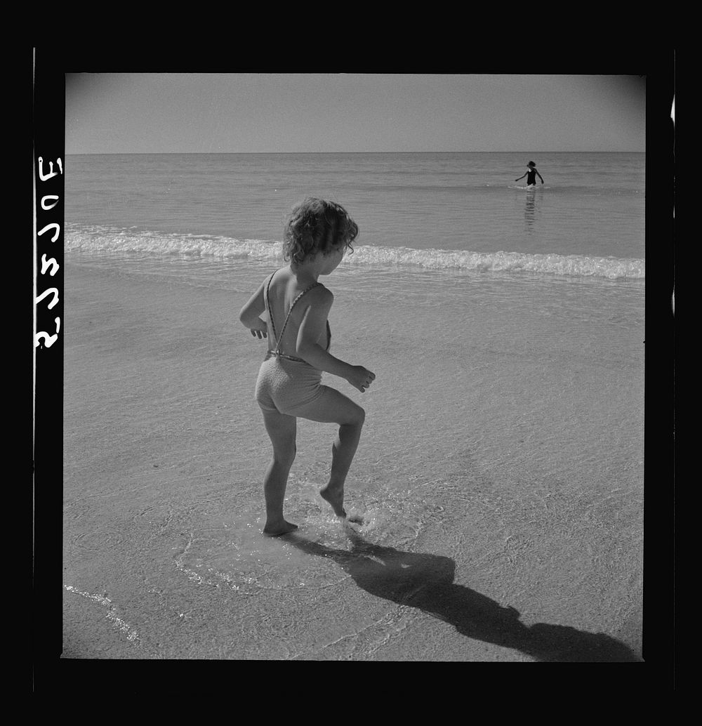 Daughter of parents living at Sarasota trailer park, Sarasota, Florida, playing in the water at the beach. Sourced from the…