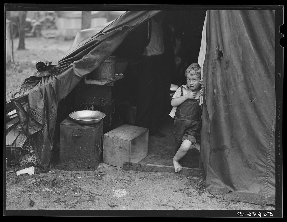 [Untitled photo, possibly related to: Child of construction worker in doorway of tent home near Alexandria, Louisiana. Ten…