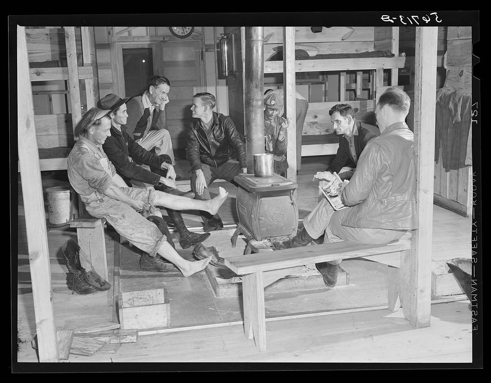 Construction workers around stove after work in new craftsmen's barracks. Camp Blanding, Florida. Sourced from the Library…