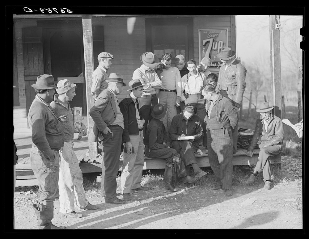Spanish trappers and fur buyers crowd around FSA (Farm Security Administration) supervisor as he opens and reads the bids on…