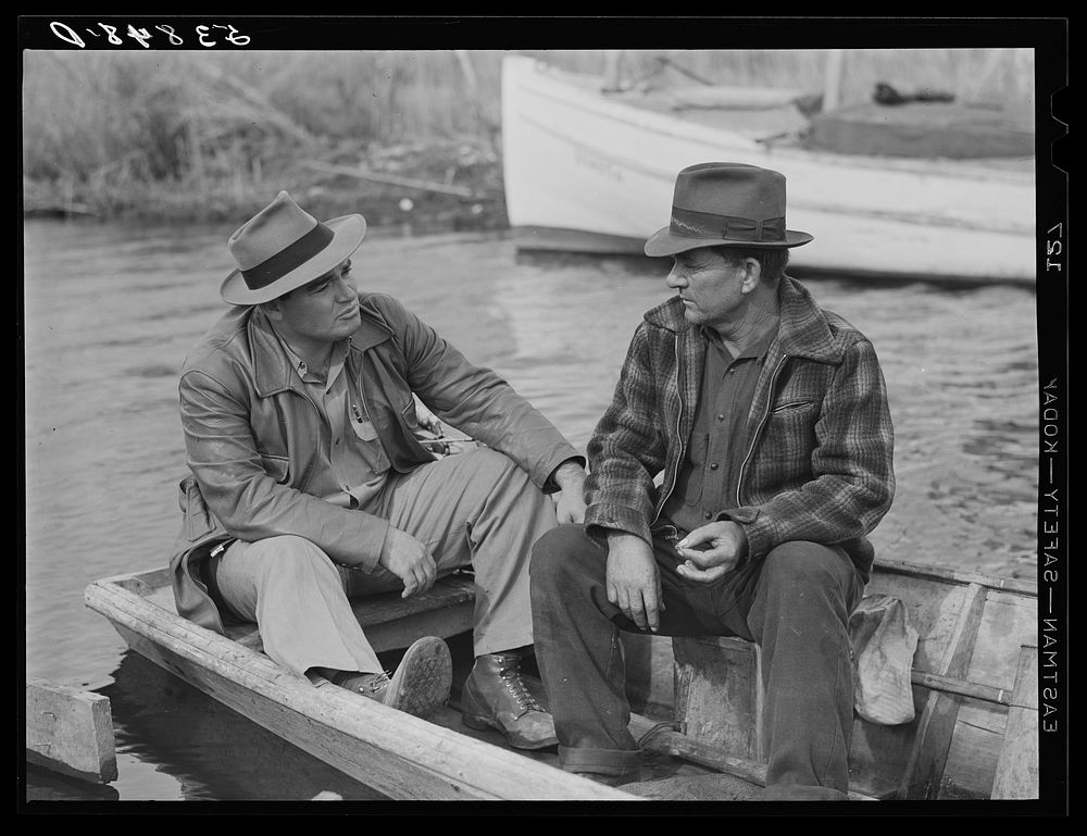 FSA (Farm Security Administration) supervisor talking to one of the trappers in his boat by one of the bayou marsh camps.…