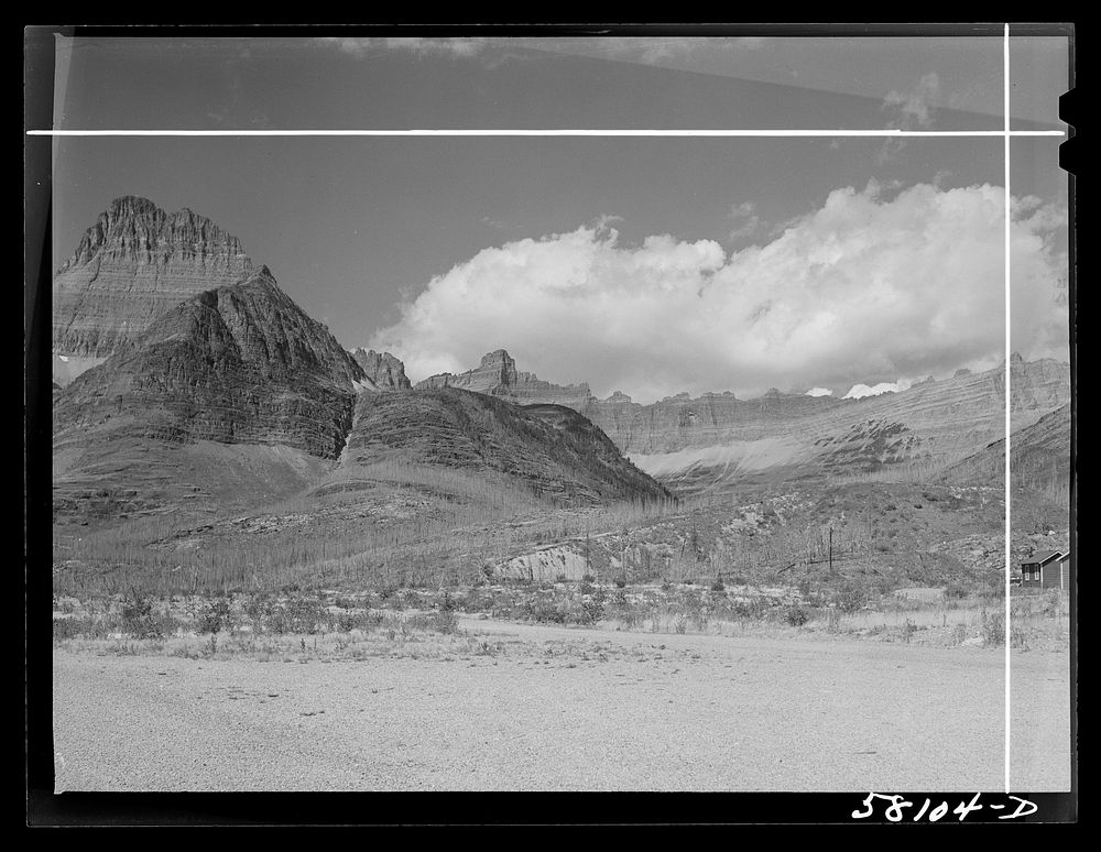 Burnt-over land, evidences of forest fire, rocky wall from Many Glacier highway. Glacier National Park, Montana. Sourced…