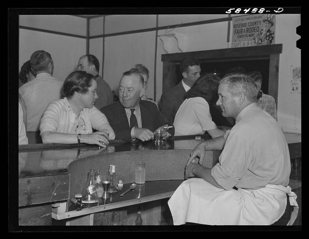 Mrs. Lyman Brewster talking with an acquaintance at the bar in Birney, Montana. Sourced from the Library of Congress.