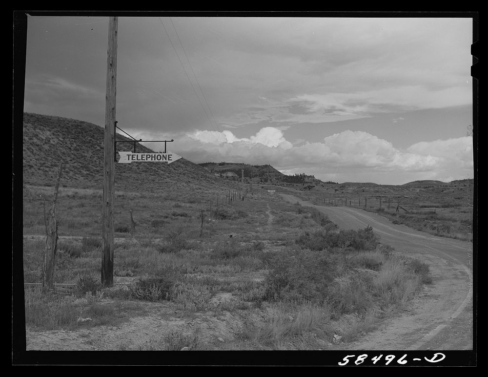[Untitled photo, possibly related to: Sign at crossroads pointing direction to nearest telephone in ranch country. Birney…