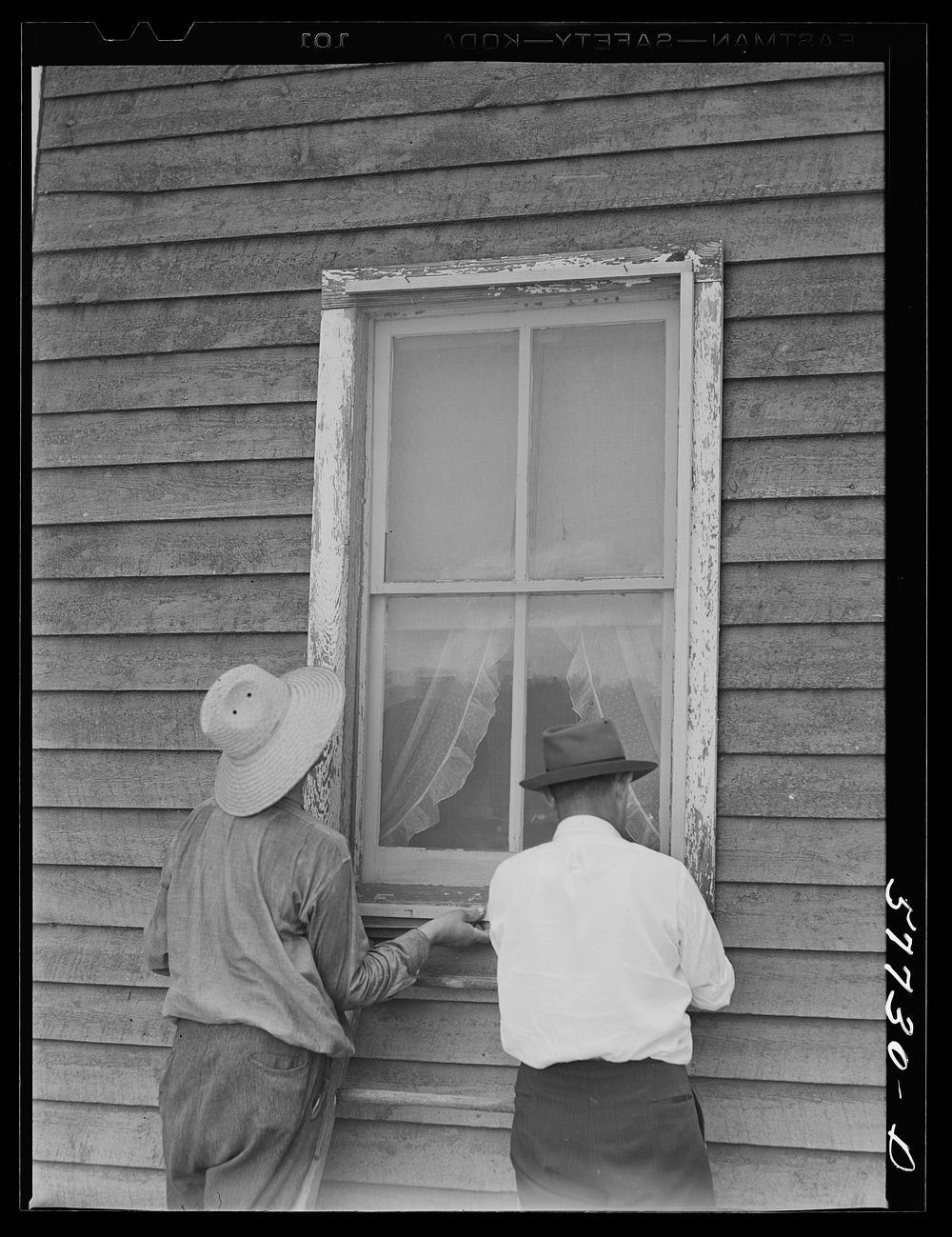 The window is screened except for nailing the last window strip. Screening demonstration. Charles County, La Plata…