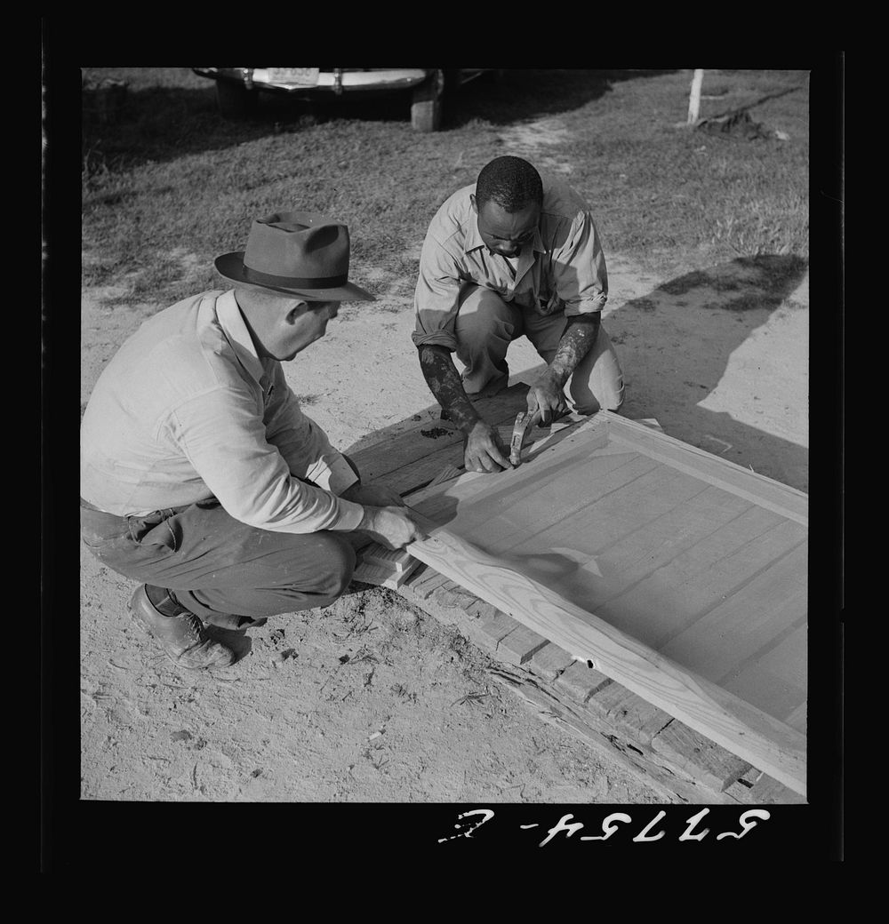 Screen is tacked to top of door first. Demonstration of home screen door construction. Saint Mary's County, Maryland, Ridge.…