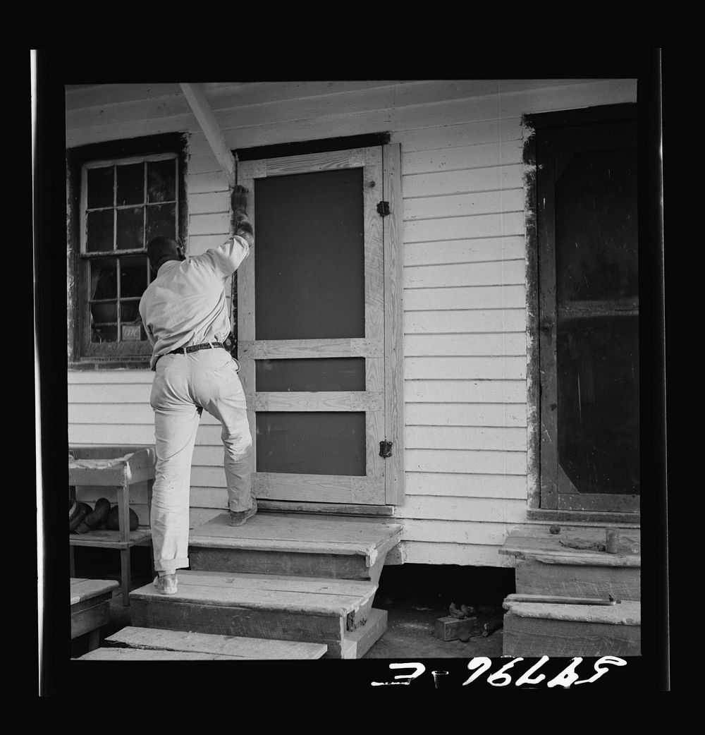 Assembling screen door to door frame. Screening demonstration. Saint Mary's County, Ridge, Maryland. Sourced from the…
