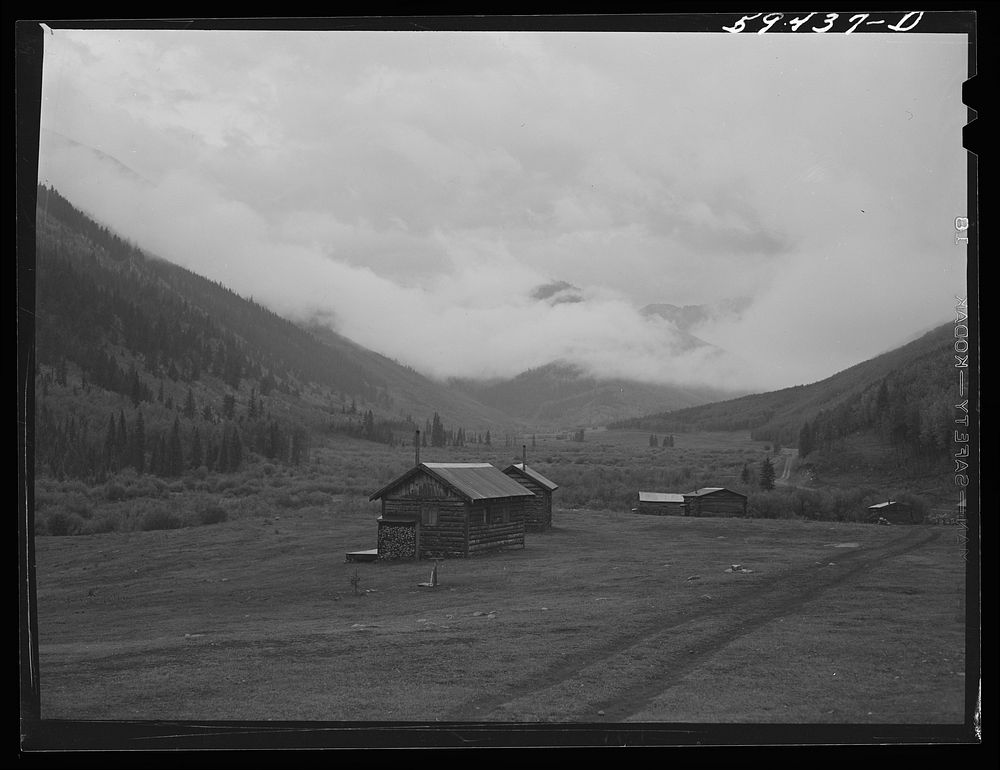 Cabins on ranch. Mist and clouds over mountains before an early blizzard. Sourced from the Library of Congress.