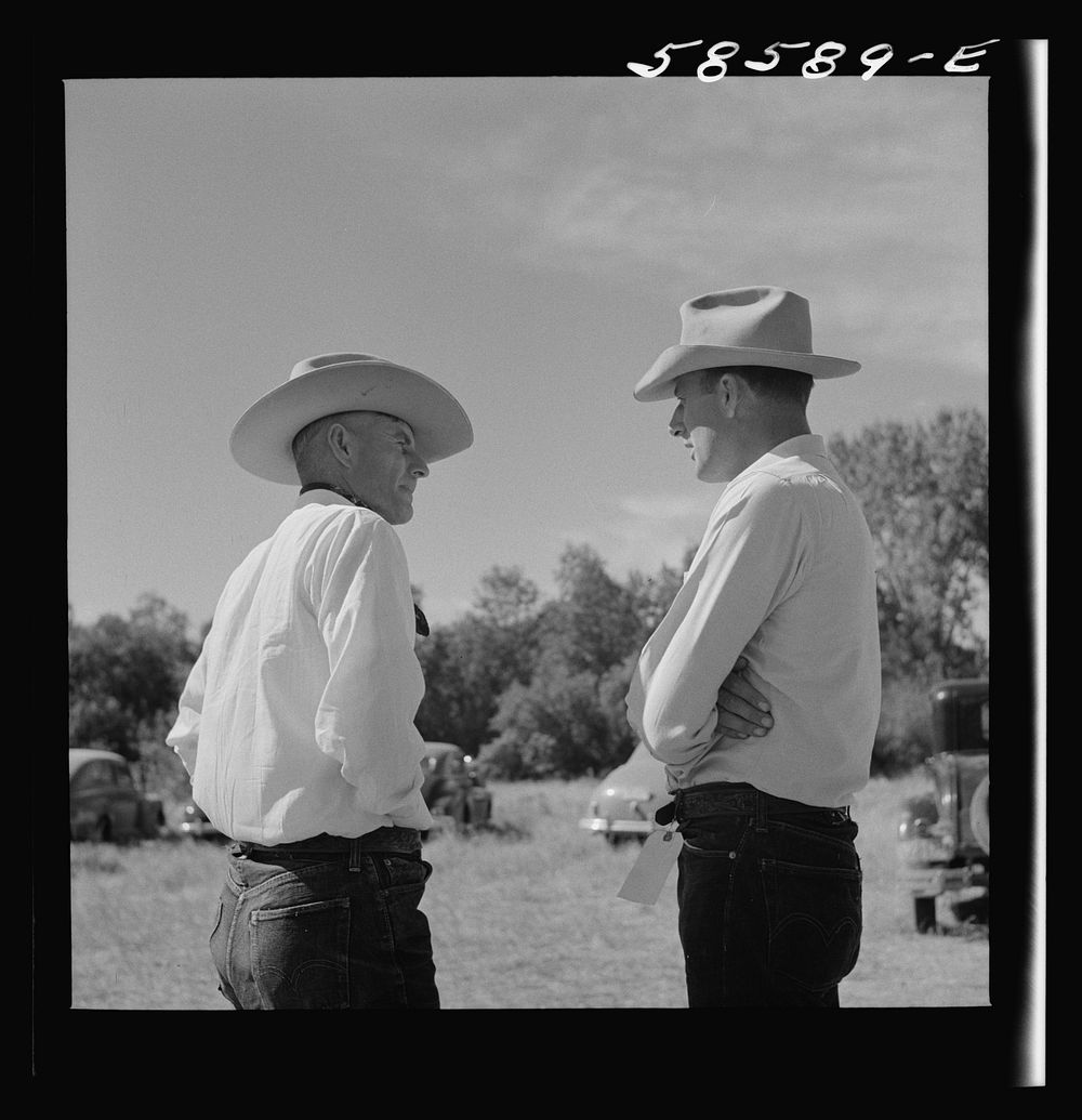[Untitled photo, possibly related to: Lyman Brewster from Quarter Circle U Ranch in Birney, Montana, talking to a neighbor…