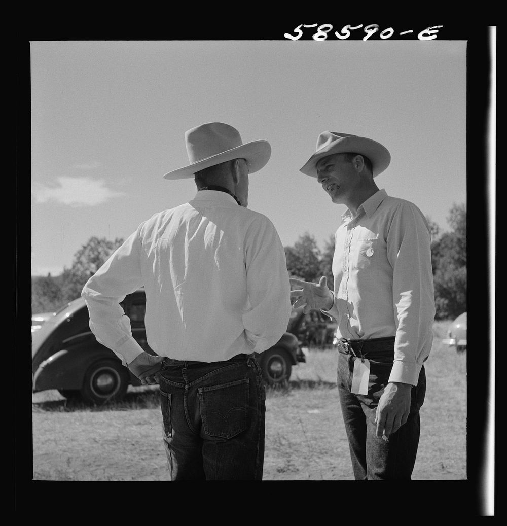 Lyman Brewster from Quarter Circle U Ranch in Birney, Montana, talking to a neighbor stockman at stockmen's picnic and…