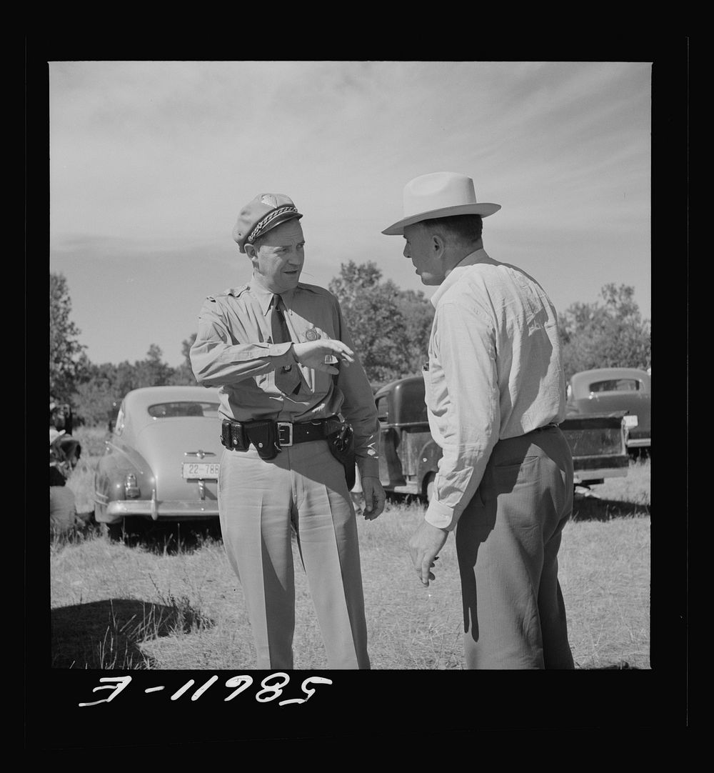 Policeman with friend at stockmen's picnic and barbecue. Spear's Siding, Wyola, Montana. Sourced from the Library of…