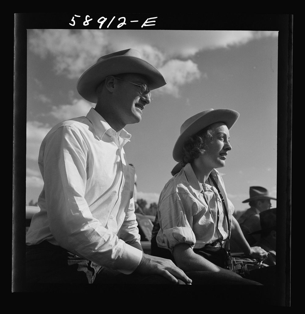 Dudes from Quarter Circle U Ranch watching the rodeo at the Crow Indian fair. Crow Agency, Montana. Sourced from the Library…