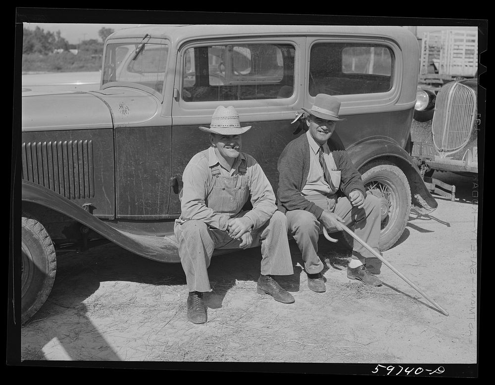 Men outside the Union Livestock Commission Company during an auction sale. Gering, Nebraska. Sourced from the Library of…