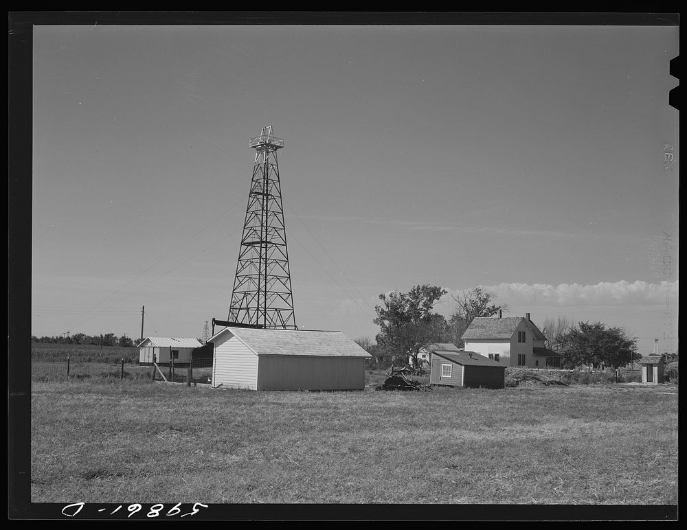 Oil well derrick in farmer's backyard. Goodrich field of Continental oil company. Valley Center Oil field near Wichita…