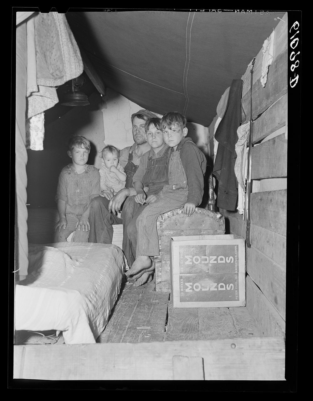 Migrant fruit worker and sons living in rear of truck during cherry picking season. Berrien County, Michigan. Sourced from…