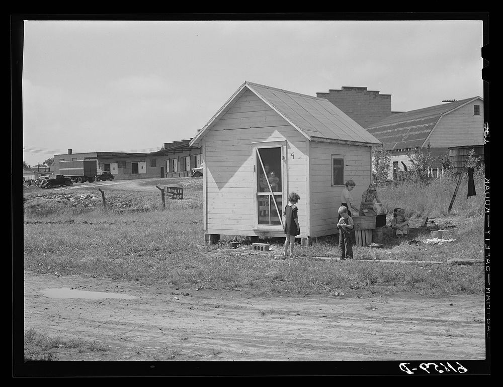 One of the nine cabins adjoining fruit packing plant. Families of seven and eight sometimes live in these one dollar and…