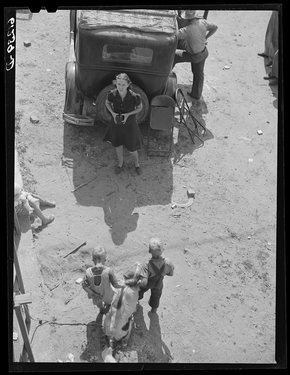 [Untitled photo, possibly related to: Loading household goods into cars and trailer. Two families getting ready to move on…