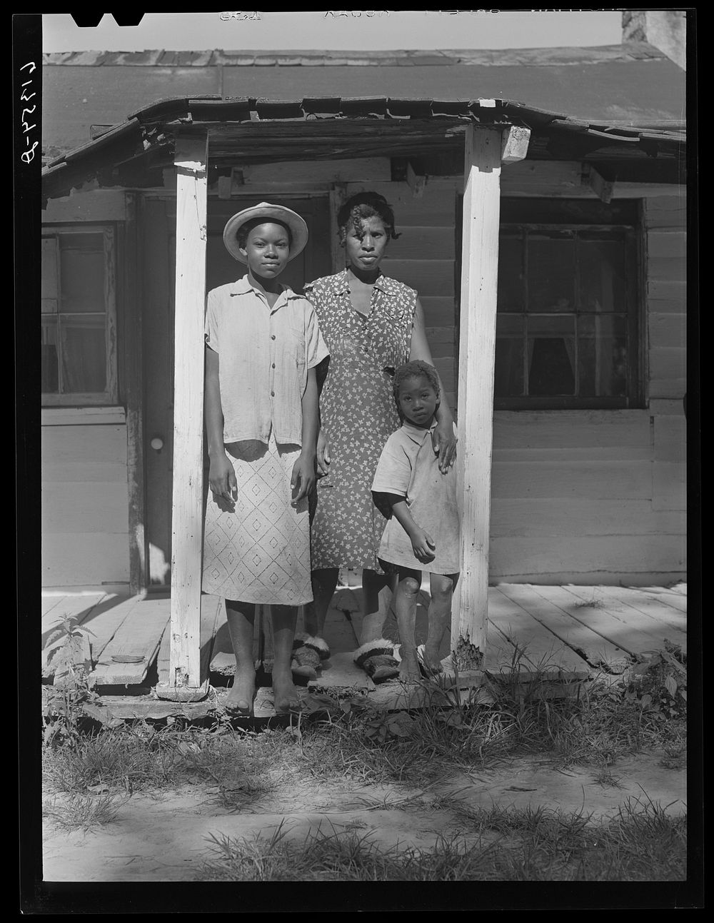 [Untitled photo, possibly related to: Mrs. Calip White and two of her children on front porch of their home near Scotland…