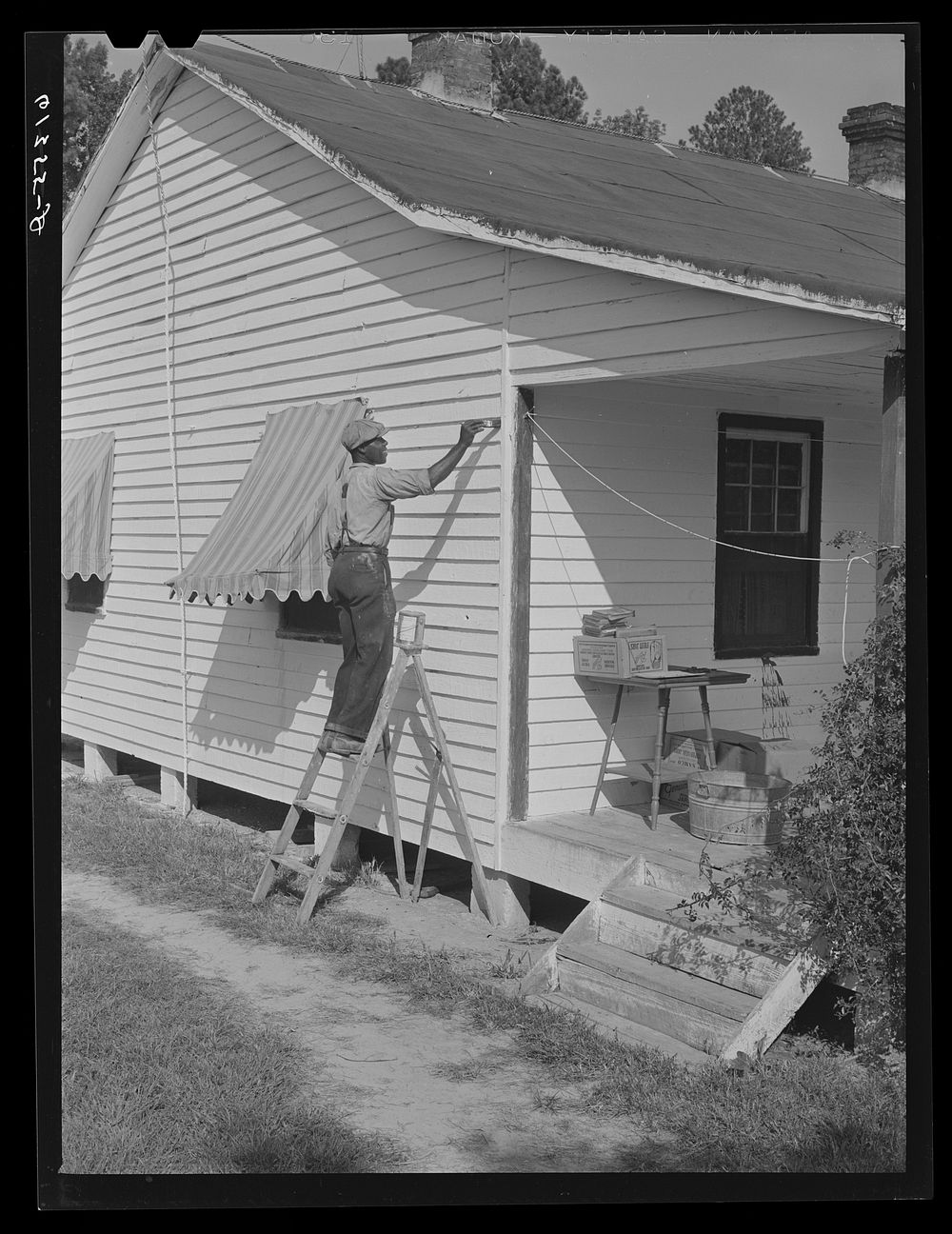 Harry Handy, FSA (Farm Security Administration) borrower, whitewashing his house. Saint Mary's County, Maryland. Sourced…