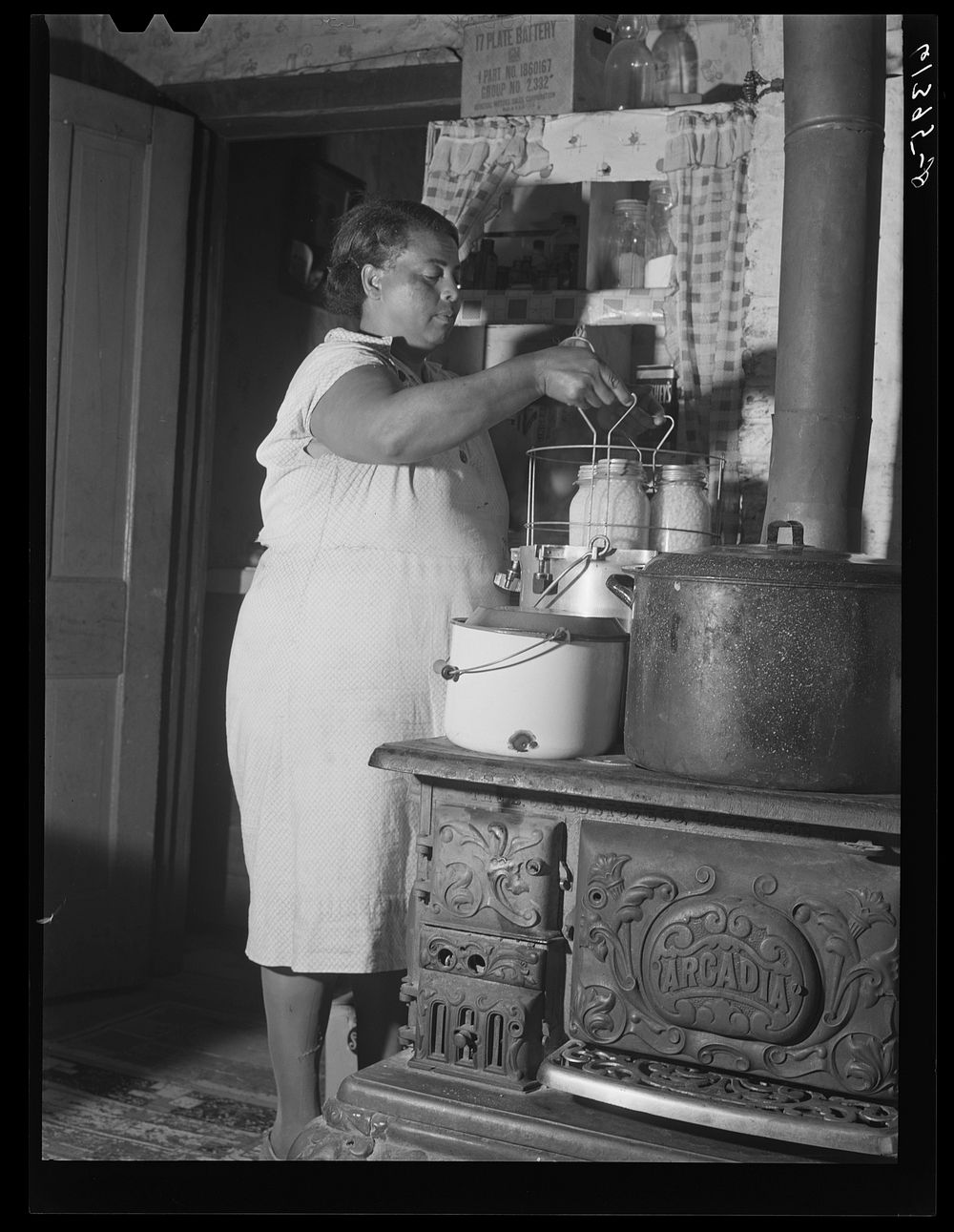 Mrs. Harry Handy canning corn with aid of pressure cooker. Saint Mary's County, Maryland. Sourced from the Library of…