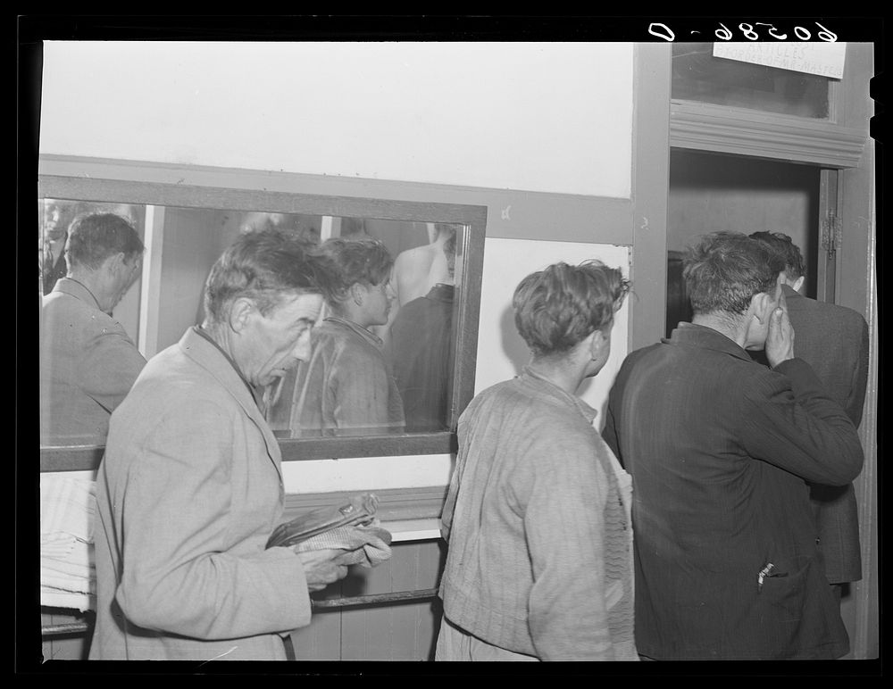 Transient men waiting to have their clothes fumigated and take showers. City mission, Dubuque, Iowa. Sourced from the…