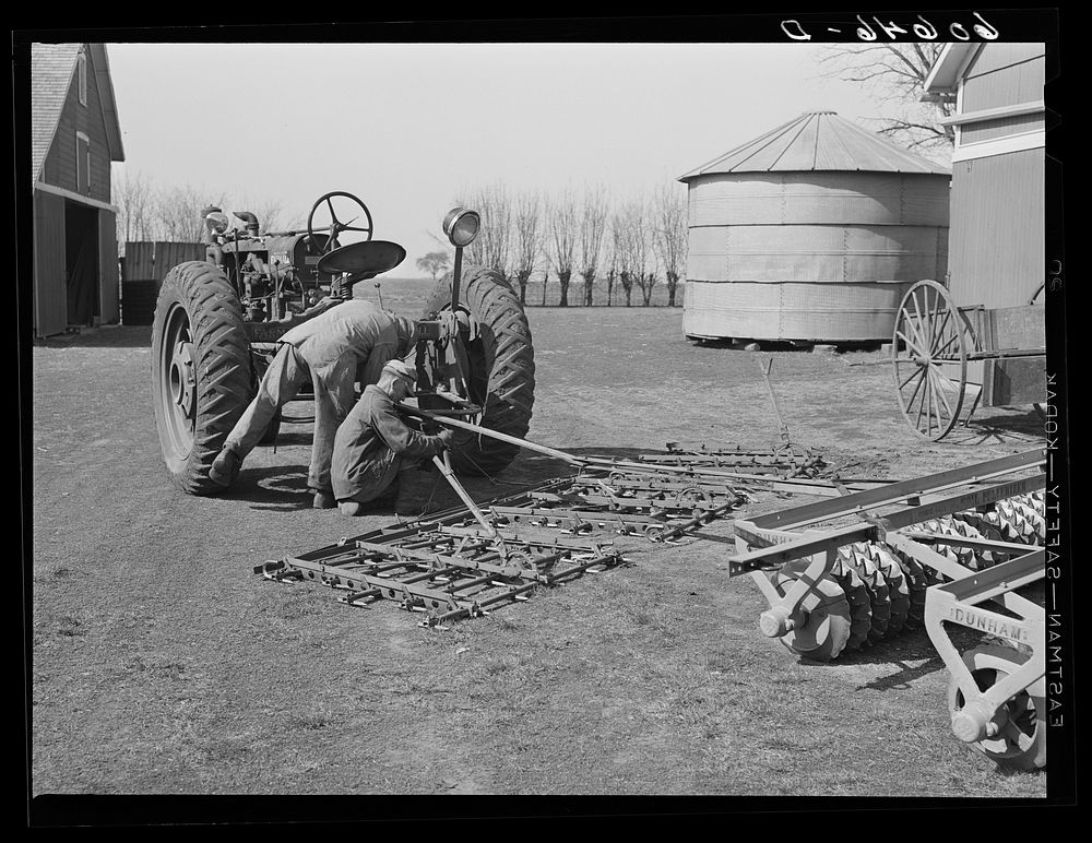 Fred Coulter's hired men attaching spike tooth harrow to tractor. Grundy County, Iowa. Sourced from the Library of Congress.