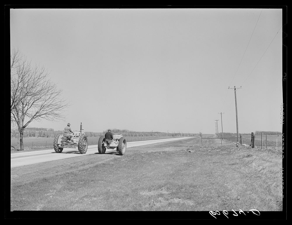 Father and son drive tractors a mile down the road to a field which belongs to them. They are breaking down stalks and…