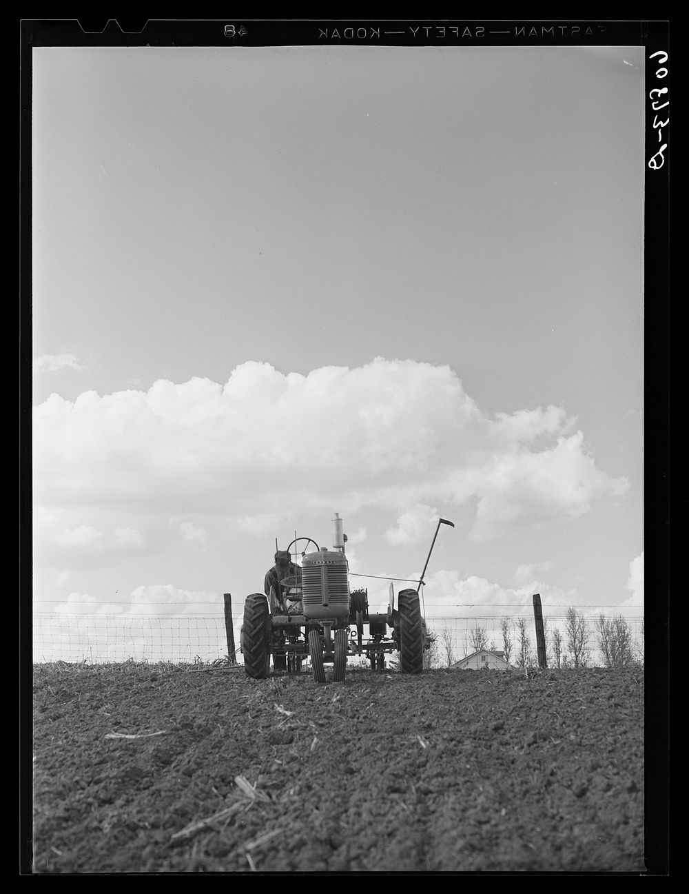 Adjusting wire on two-row tractor planter. Jasper County, Iowa. Sourced from the Library of Congress.