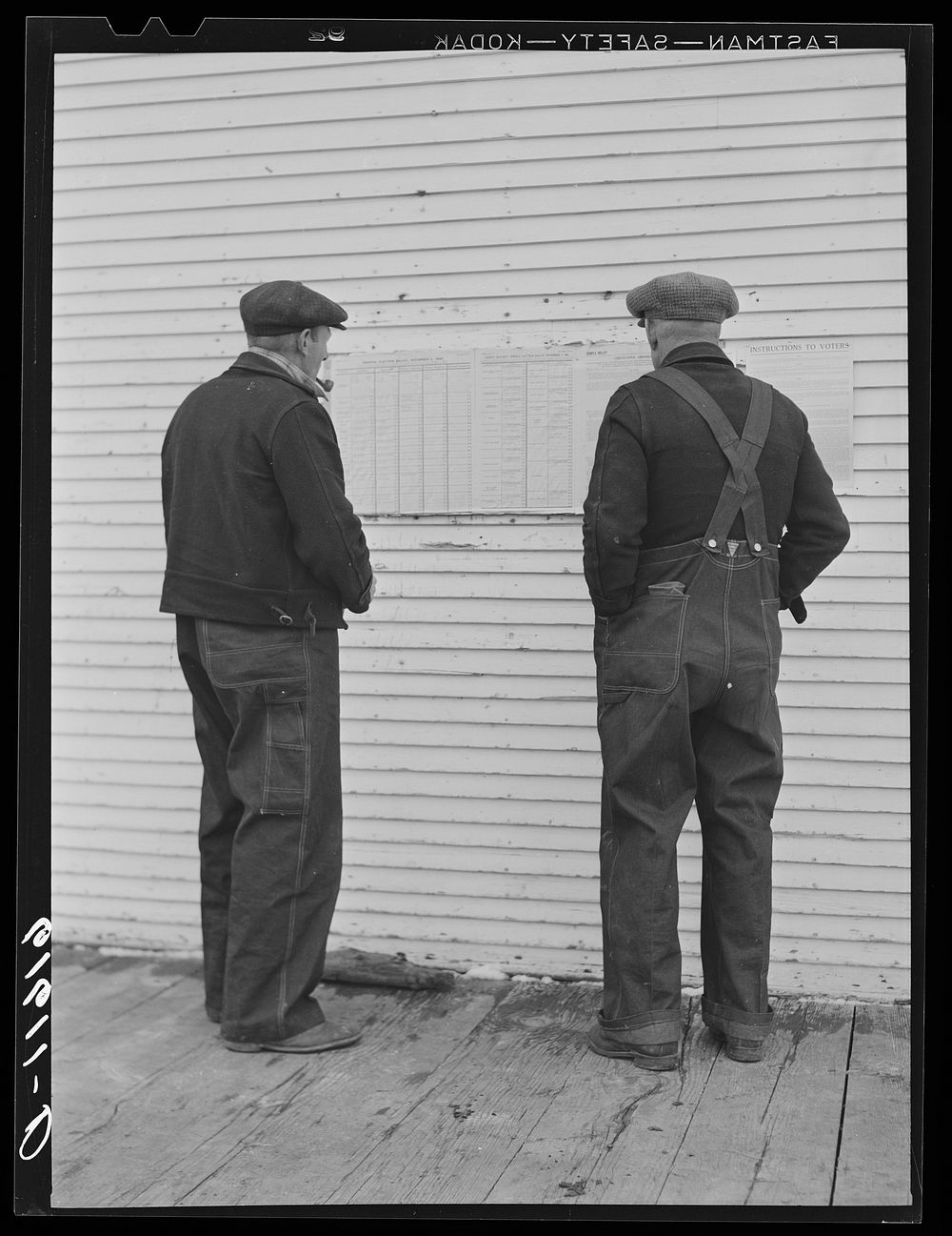 Farmers looking at ballots posted outside of schoolhouse. Election day, McIntosh County, North Dakota. Sourced from the…