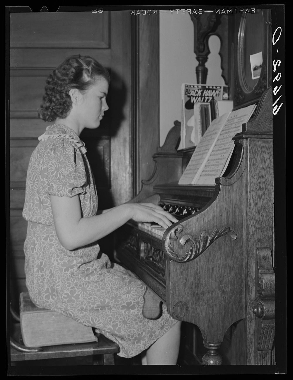 Farm girl playing organ in home. McIntosh County, North Dakota. Sourced from the Library of Congress.