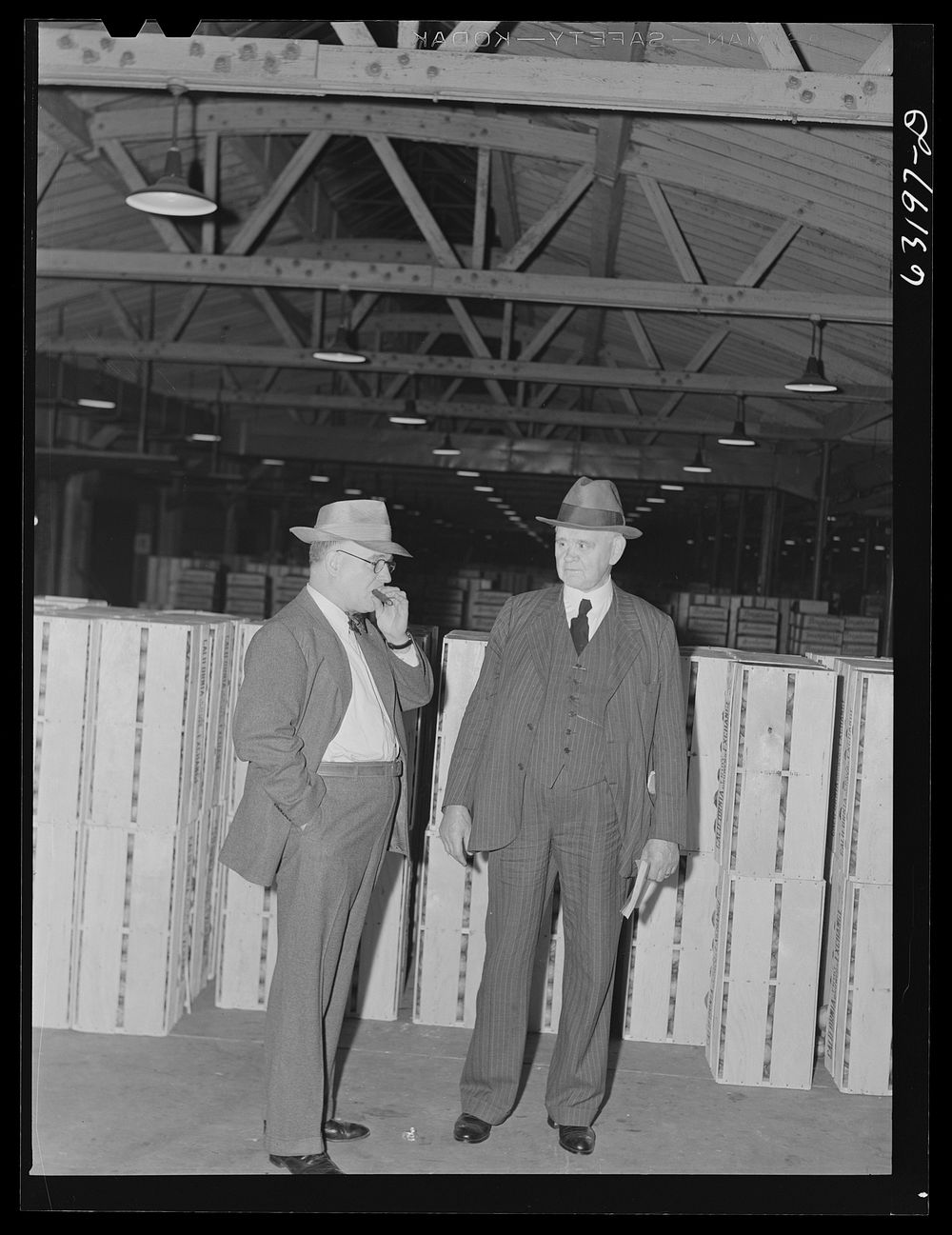 Commission merchants before early morning auction begins. Fruit terminal warehouse. Chicago, Illinois. Sourced from the…